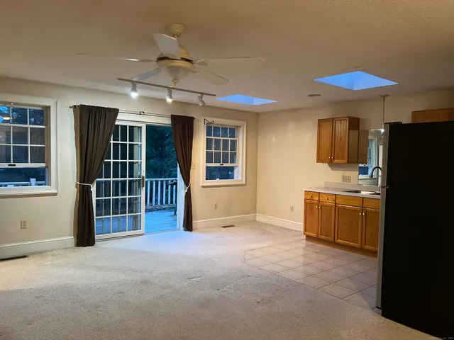 an empty room with a window and a fan