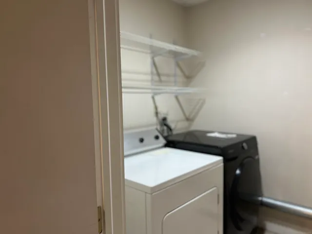 a view of an empty room with a kitchen and a window