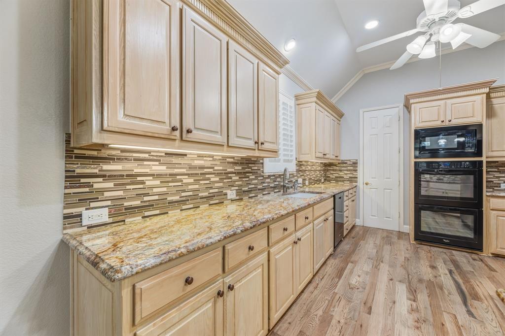 358 Pine Valley Fairview, TX 75069 - Photo 17 of 39 a kitchen with granite countertop cabinets a sink and dishwasher