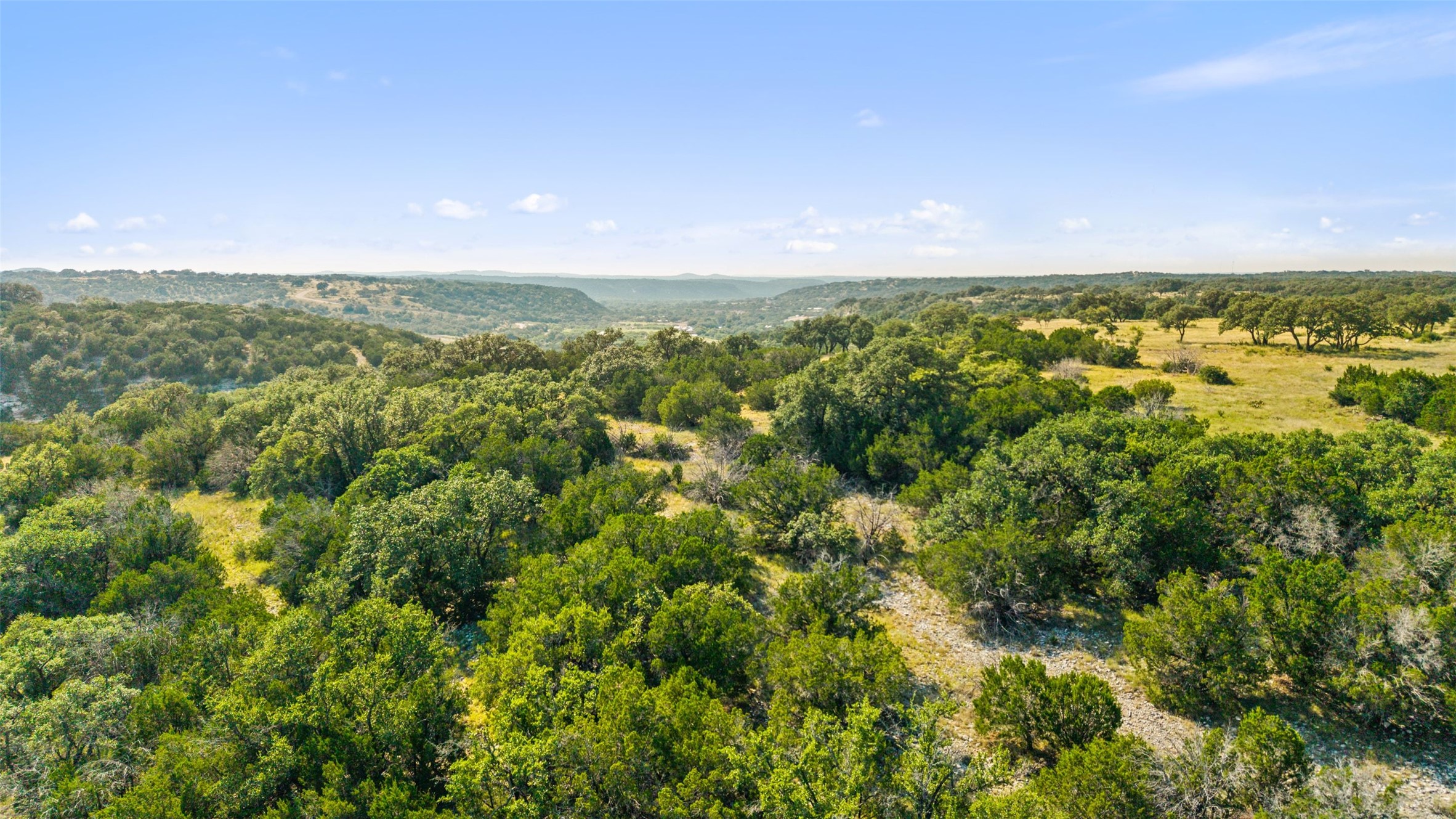 2915 Spring Crossing Junction, TX 76849 - Photo 7 of 31 Rolling hills and mature trees create a private, tranquil setting with distant natural views.