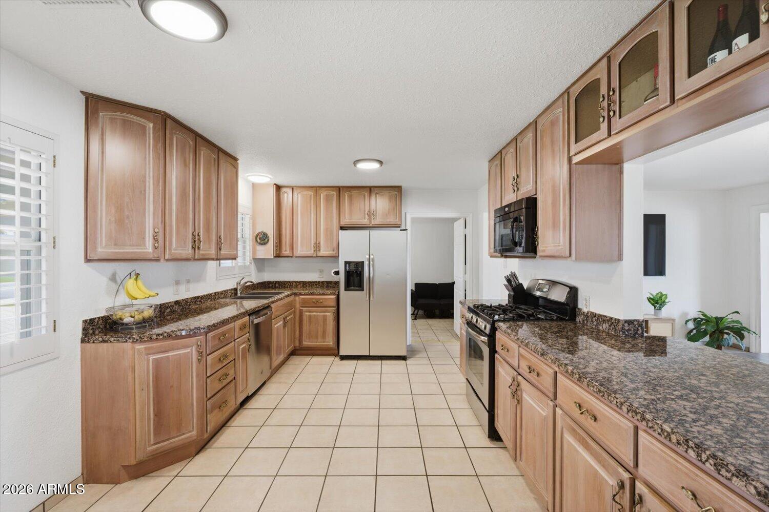 934 East Berridge Lane Phoenix, AZ 85014 - Photo 5 of 29 a kitchen with stainless steel appliances granite countertop a stove a sink and a microwave