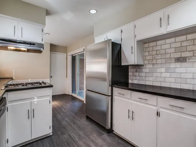a kitchen with granite countertop white cabinets and stainless steel appliances