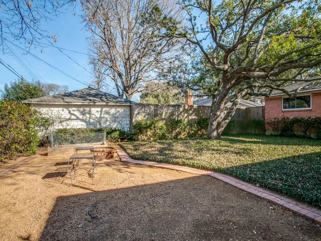 a view of a backyard with large trees