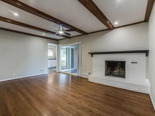 a view of an empty room with a fireplace and a window