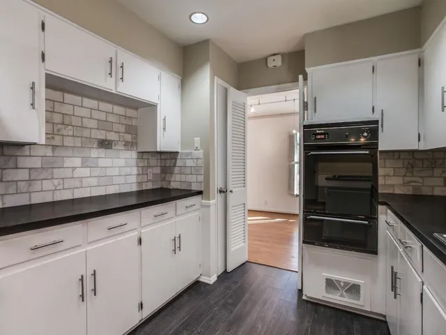 a kitchen with granite countertop a refrigerator sink and cabinets