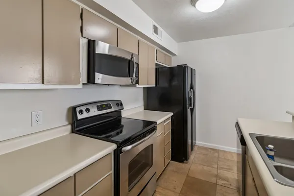 a kitchen with stainless steel appliances granite countertop a sink a stove and a refrigerator