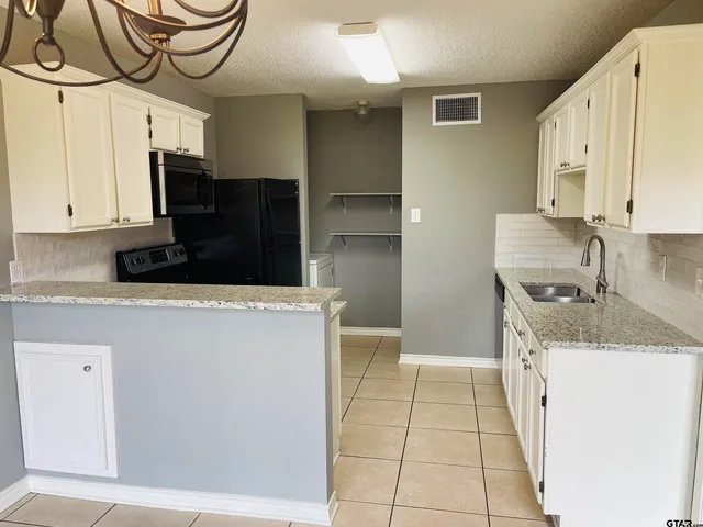 a kitchen with stainless steel appliances granite countertop a sink and a stove