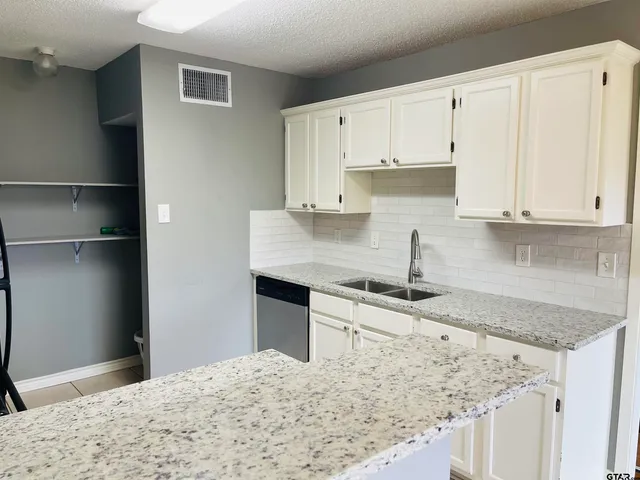 a kitchen with granite countertop a sink and a stove