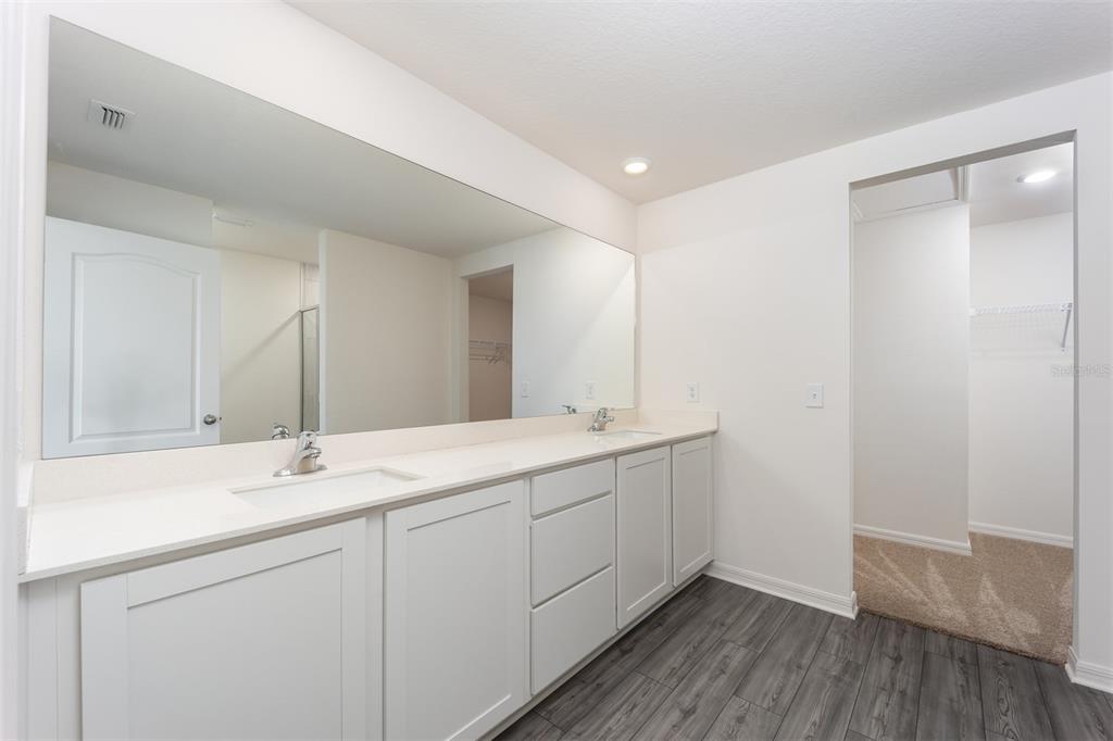 696 Poppy Lane Dundee, FL 33838 - Photo 11 of 16 a bathroom with a double vanity sink and mirror
