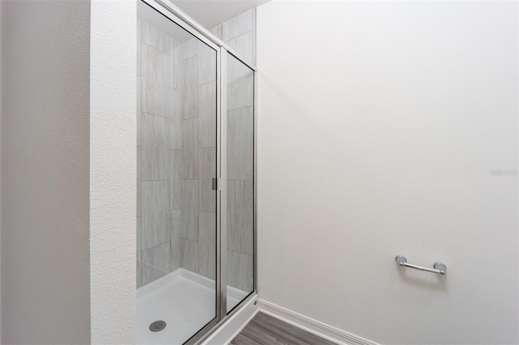 696 Poppy Lane Dundee, FL 33838 - Photo 12 of 16 a bathroom with a glass shower door
