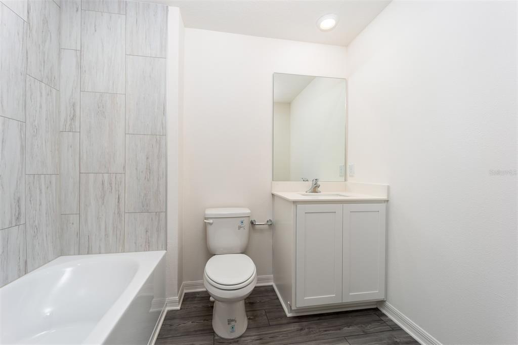 696 Poppy Lane Dundee, FL 33838 - Photo 15 of 16 a bathroom with a toilet a sink a mirror and bathtub