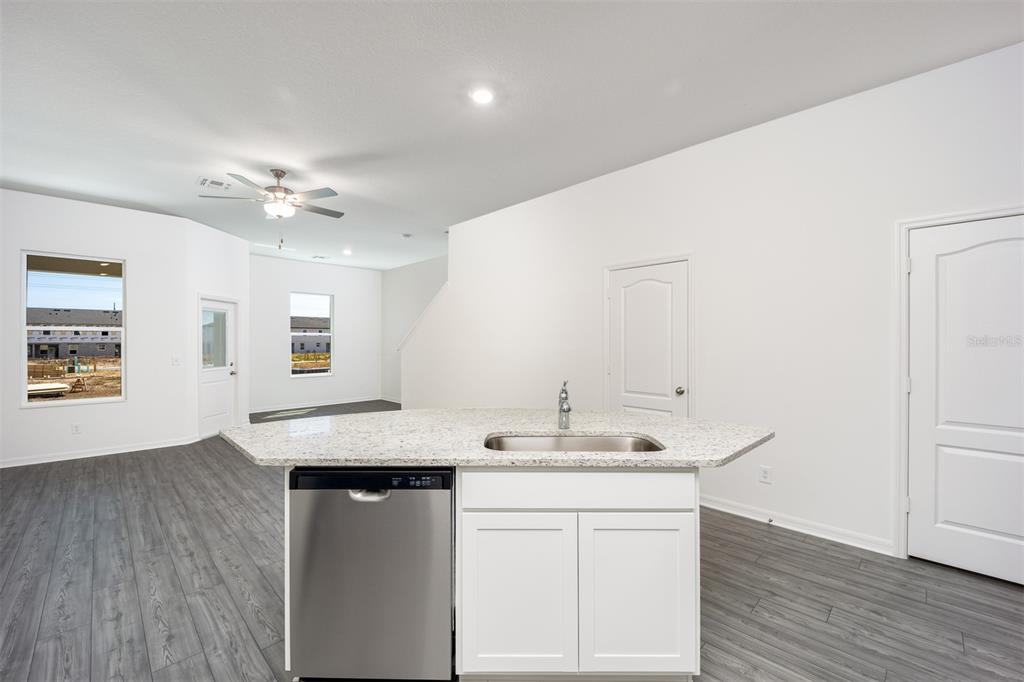 696 Poppy Lane Dundee, FL 33838 - Photo 6 of 16 a room with kitchen island a sink wooden floor and white appliances
