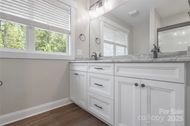 a spacious bathroom with a granite countertop sink and a mirror