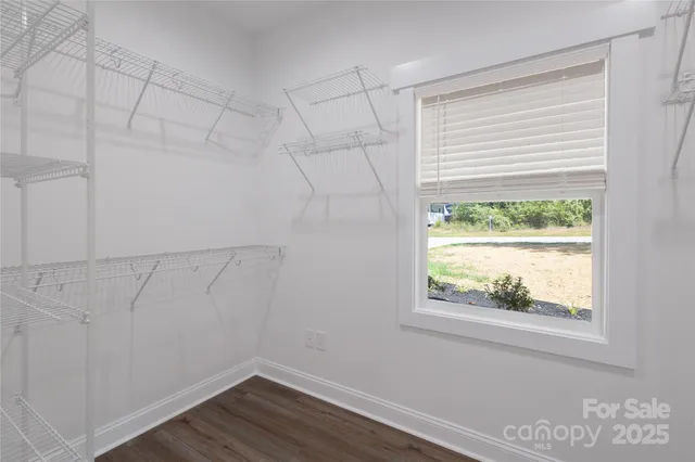 a view of a small space with wooden floor and a window
