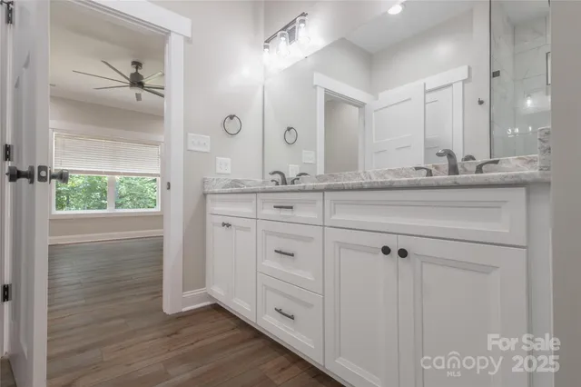 a bathroom with a granite countertop sink mirror and shower