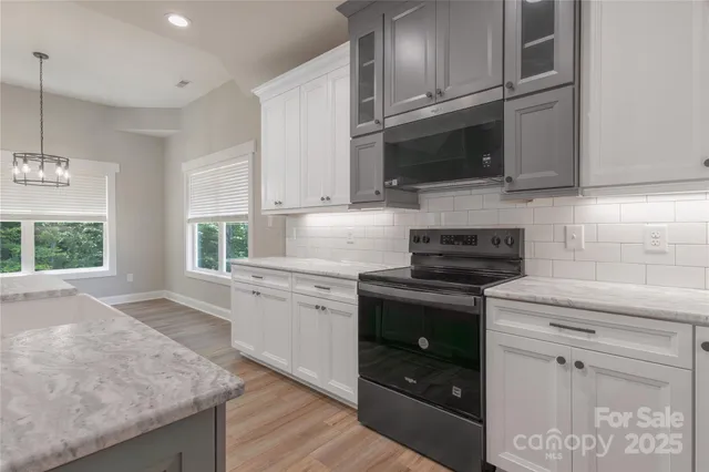 a kitchen with stainless steel appliances granite countertop a stove a sink and a microwave