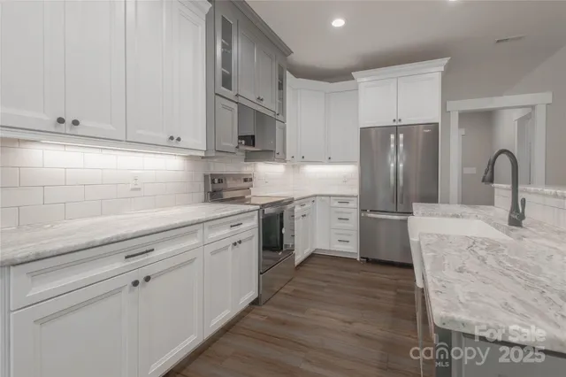 a kitchen with stainless steel appliances a refrigerator sink and cabinets