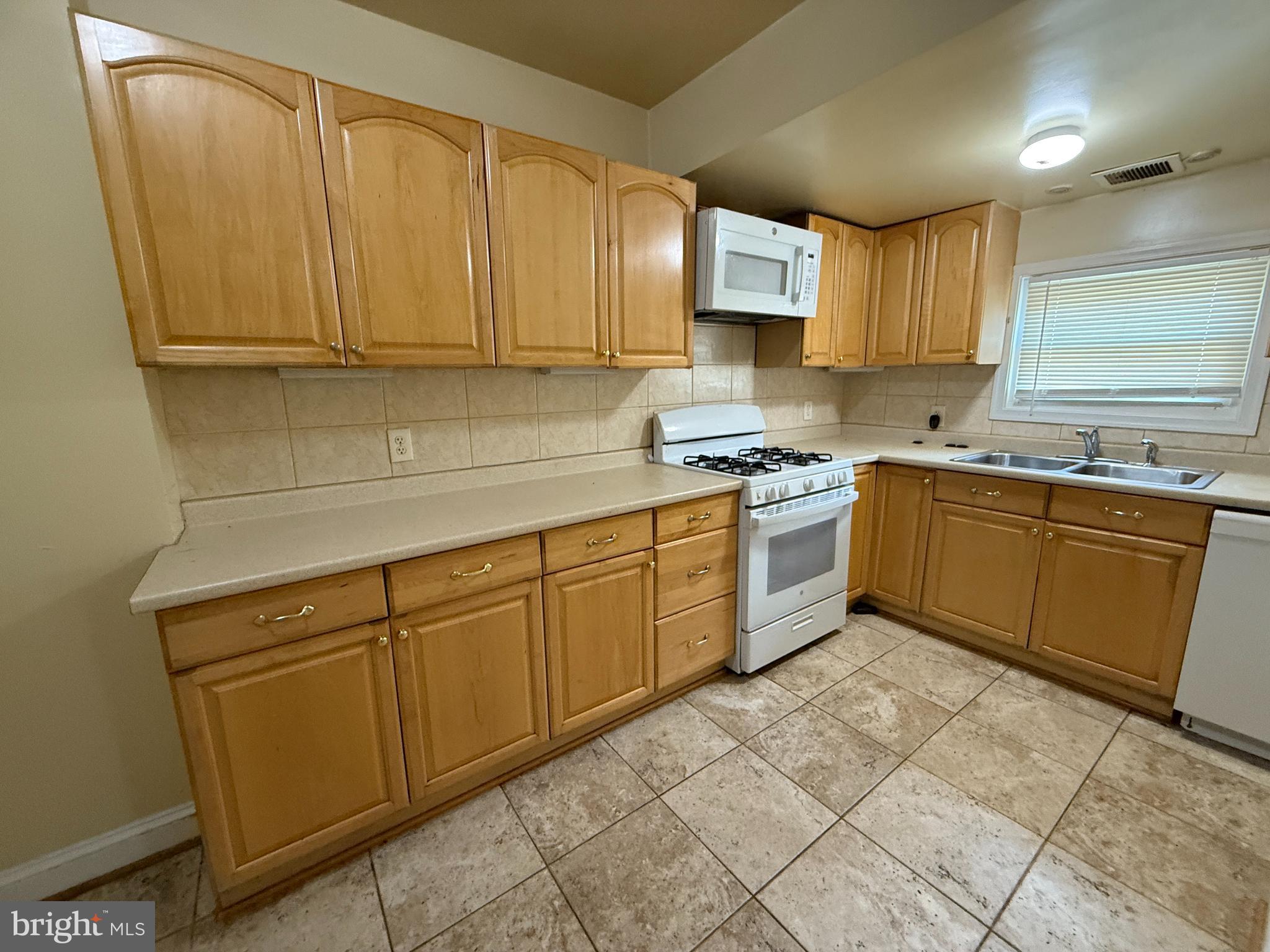 65 Willow Spring Road Baltimore, MD 21222 - Photo 6 of 16 a kitchen with stainless steel appliances granite countertop a sink a stove a refrigerator with grey cabinets