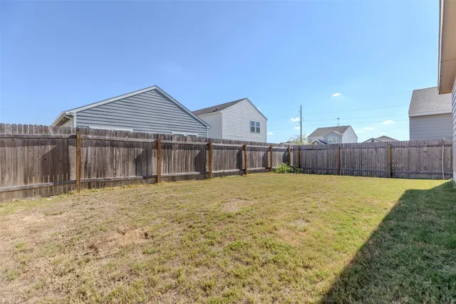 a view of a house with a yard and wooden fence