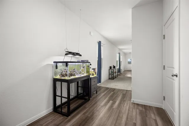 a view of a hallway with wooden floor and furniture