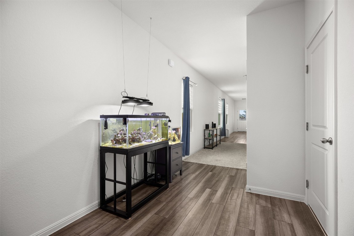 104 Enforcer Loop Jarrell, TX 76537 - Photo 4 of 12 a view of a hallway with wooden floor and furniture