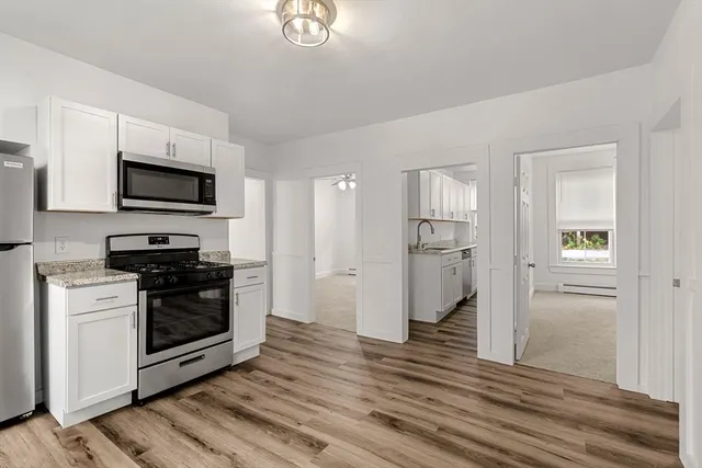 a kitchen with wooden floors and refrigerator