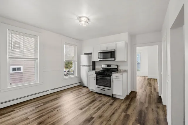 a kitchen with granite countertop white cabinets and sink