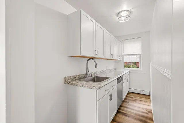 a view of a room with wooden floor and white walls