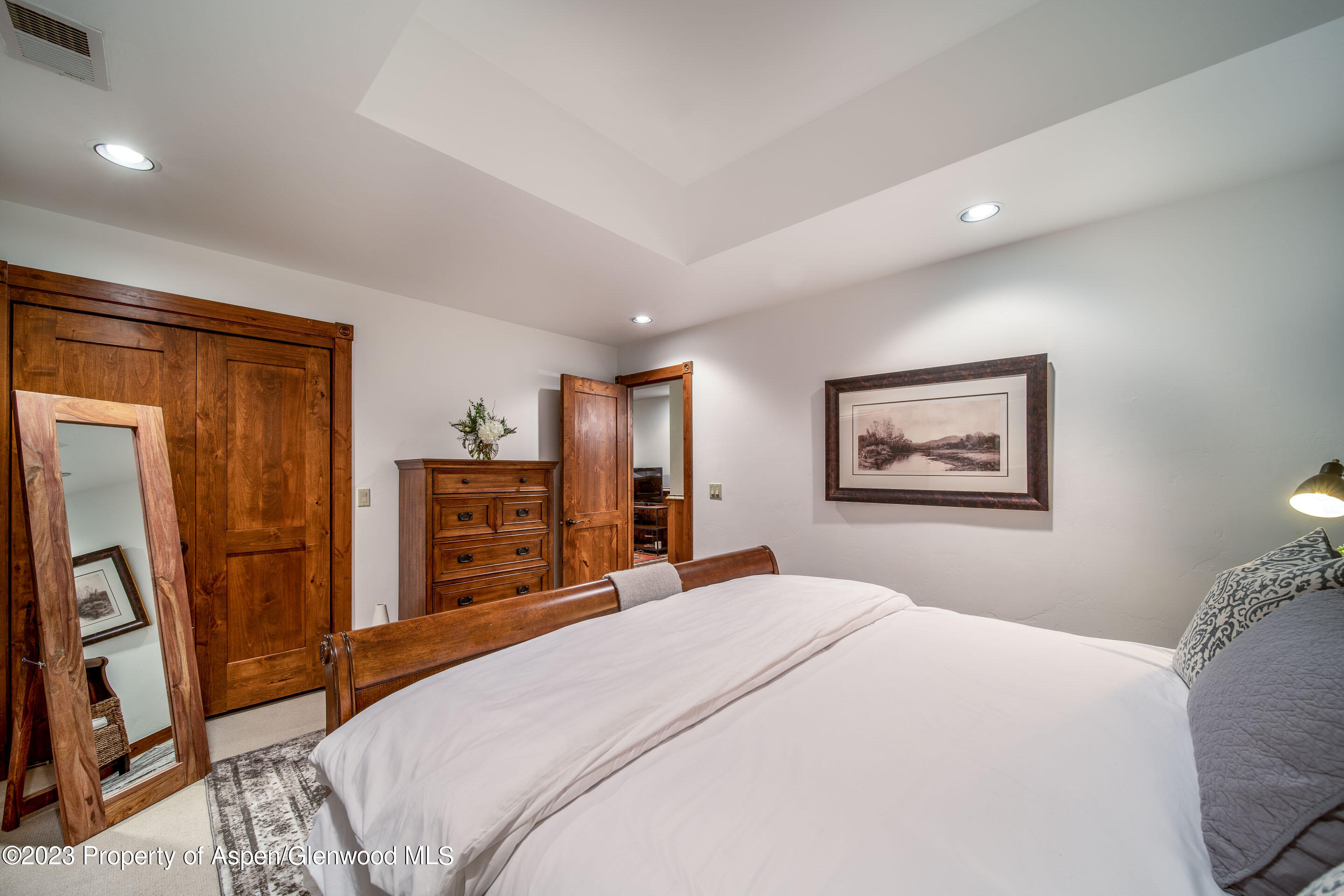 503 West Main Street, Unit B101 Aspen, CO 81611 - Photo 12 of 16 a bedroom with a large bed and a flat tv screen