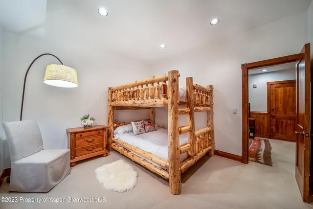 a bedroom with a large bed and a flat tv screen