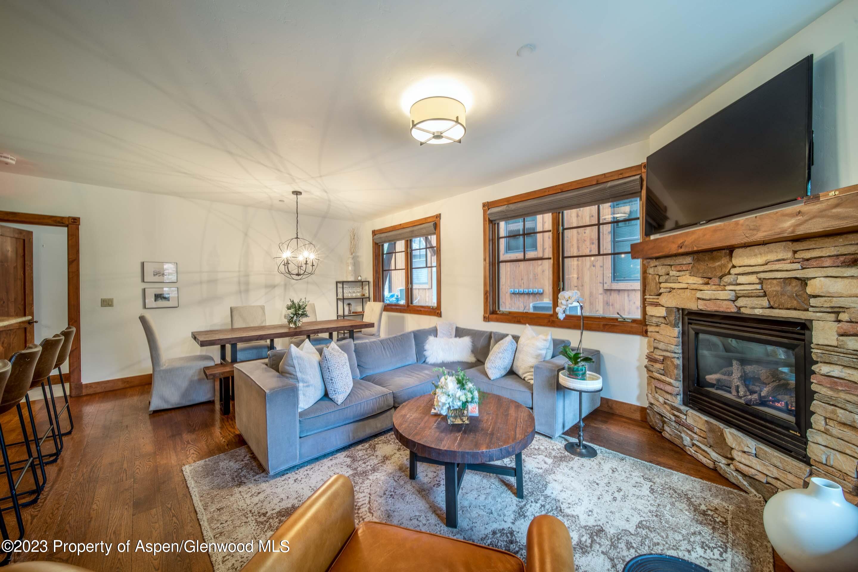 503 West Main Street, Unit B101 Aspen, CO 81611 - Photo 2 of 16 a living room with furniture a flat screen tv and a fireplace