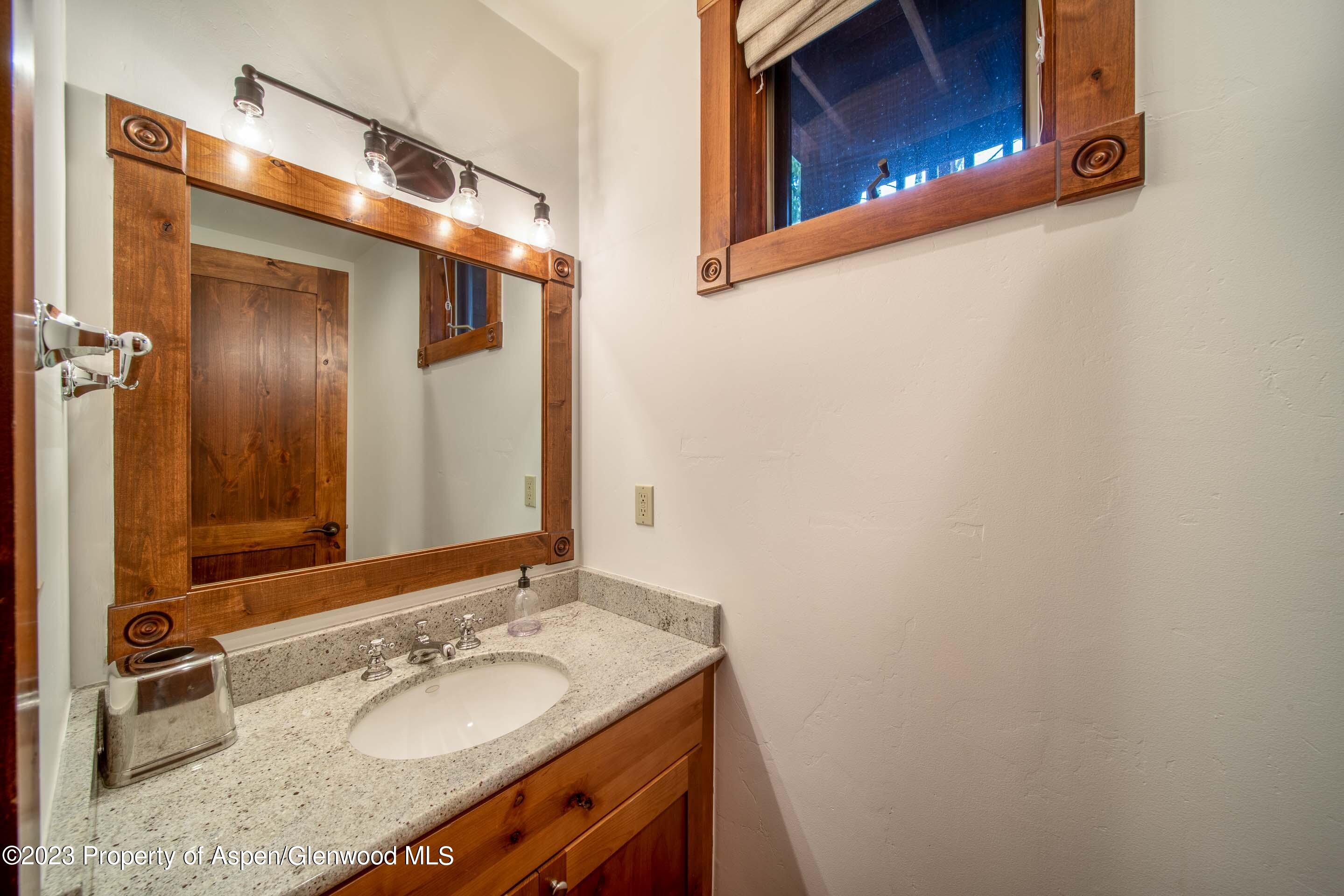 503 West Main Street, Unit B101 Aspen, CO 81611 - Photo 5 of 16 a bathroom with a granite countertop sink and mirror