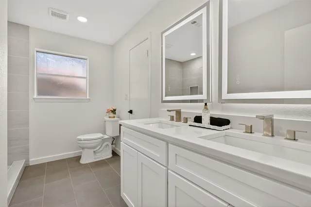 a bathroom with a toilet sink and mirror