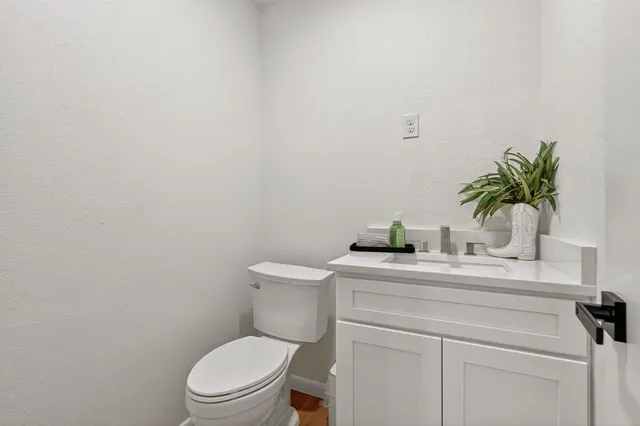 a bathroom with a granite countertop toilet sink and mirror