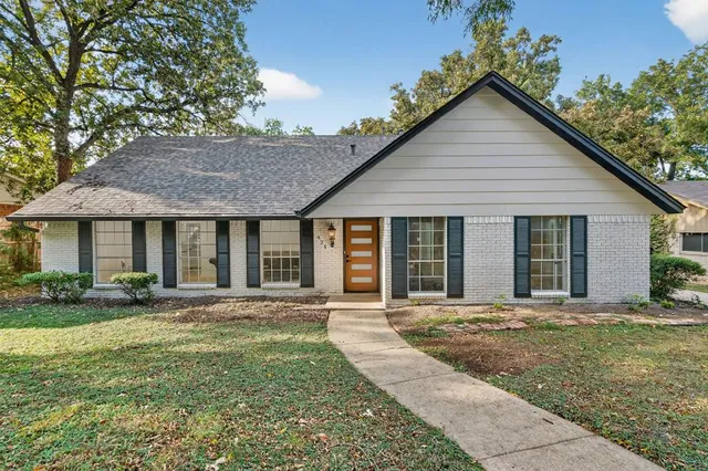 a front view of a house with a garden and yard