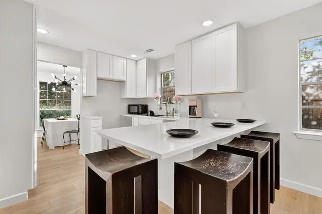 a kitchen with granite countertop a sink a stove counter top space and cabinets