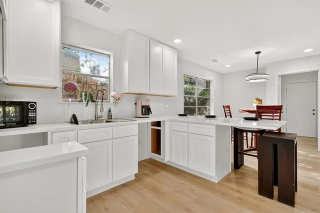 a kitchen with kitchen island granite countertop a sink cabinets and wooden floor