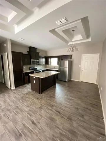 a large kitchen with stainless steel appliances a stove a refrigerator and a sink