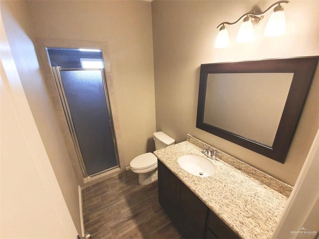 2000 Jackson Street, Unit 1 Weslaco, TX 78599 - Photo 9 of 10 a bathroom with a granite countertop sink toilet and mirror