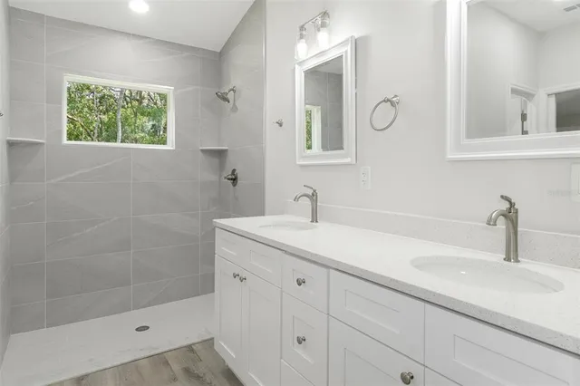 a bathroom with a sink a window and a shower