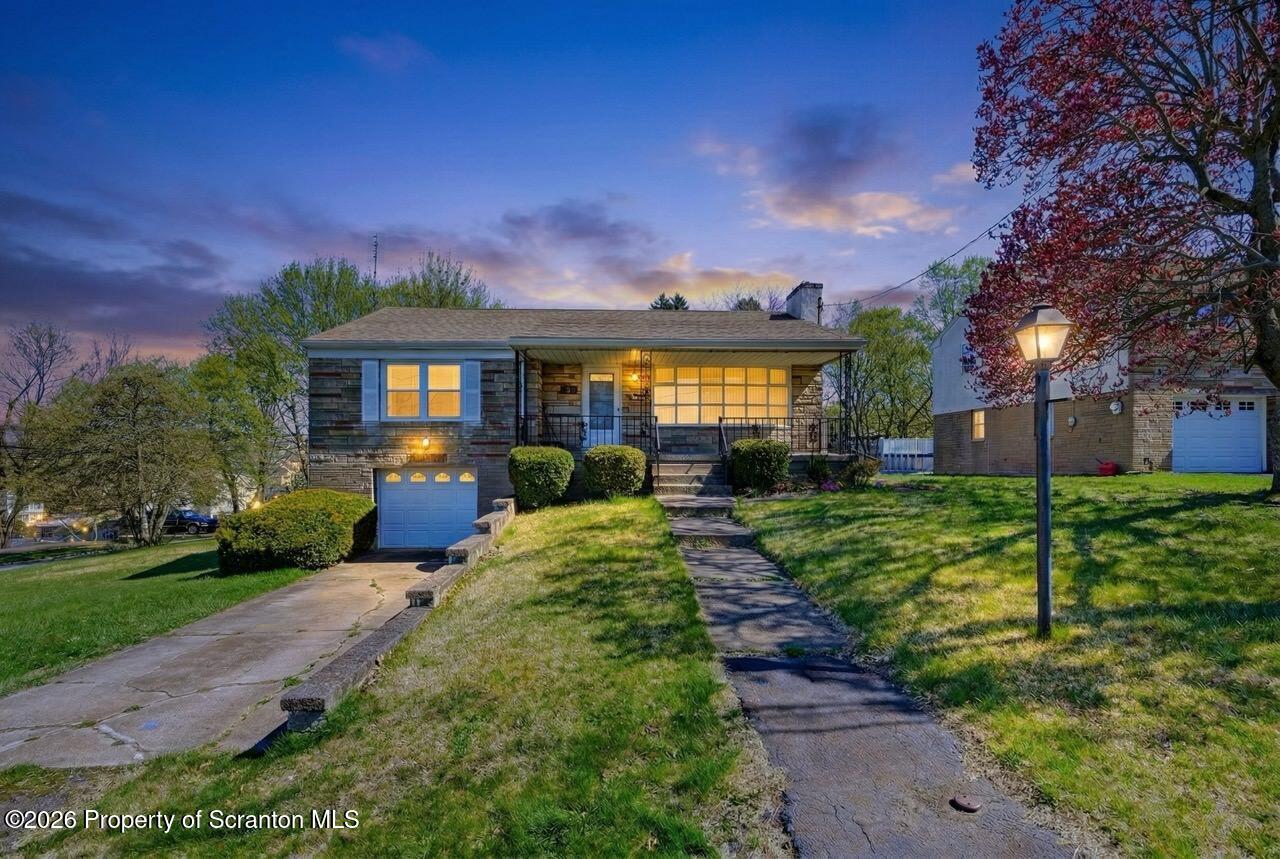 a front view of a house with a yard and green space