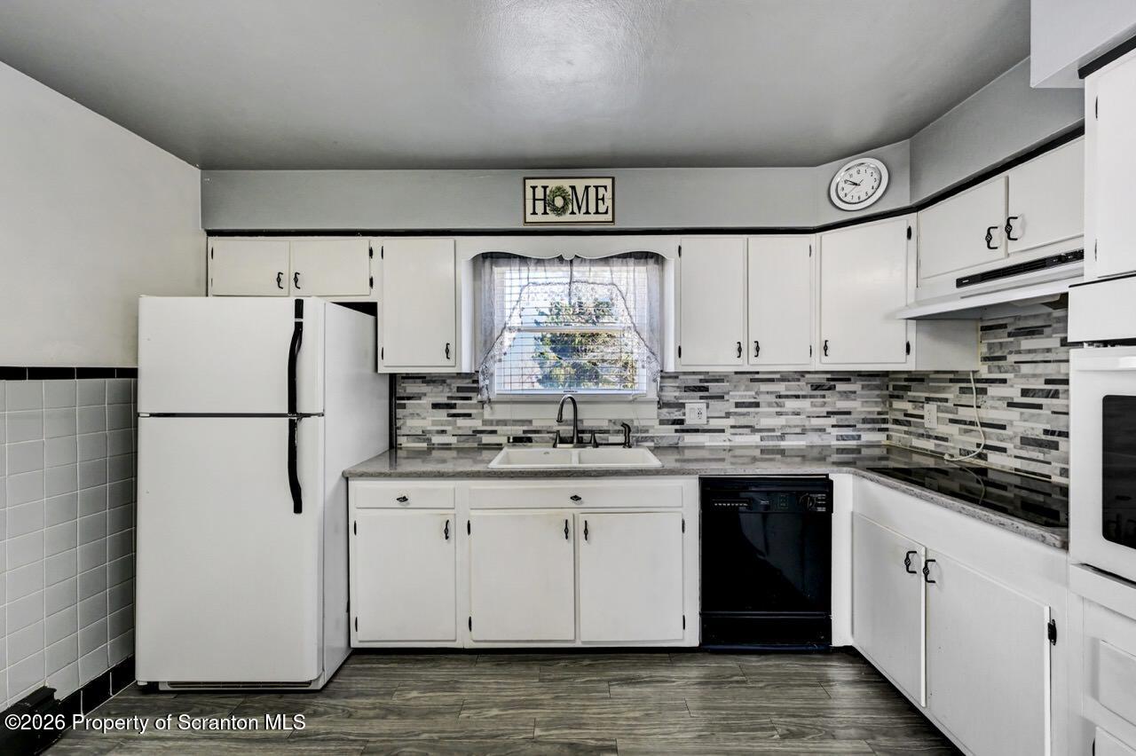 703 Ohara Street Scranton, PA 18505 - Photo 11 of 36 a kitchen with granite countertop a white refrigerator oven a sink and cabinets