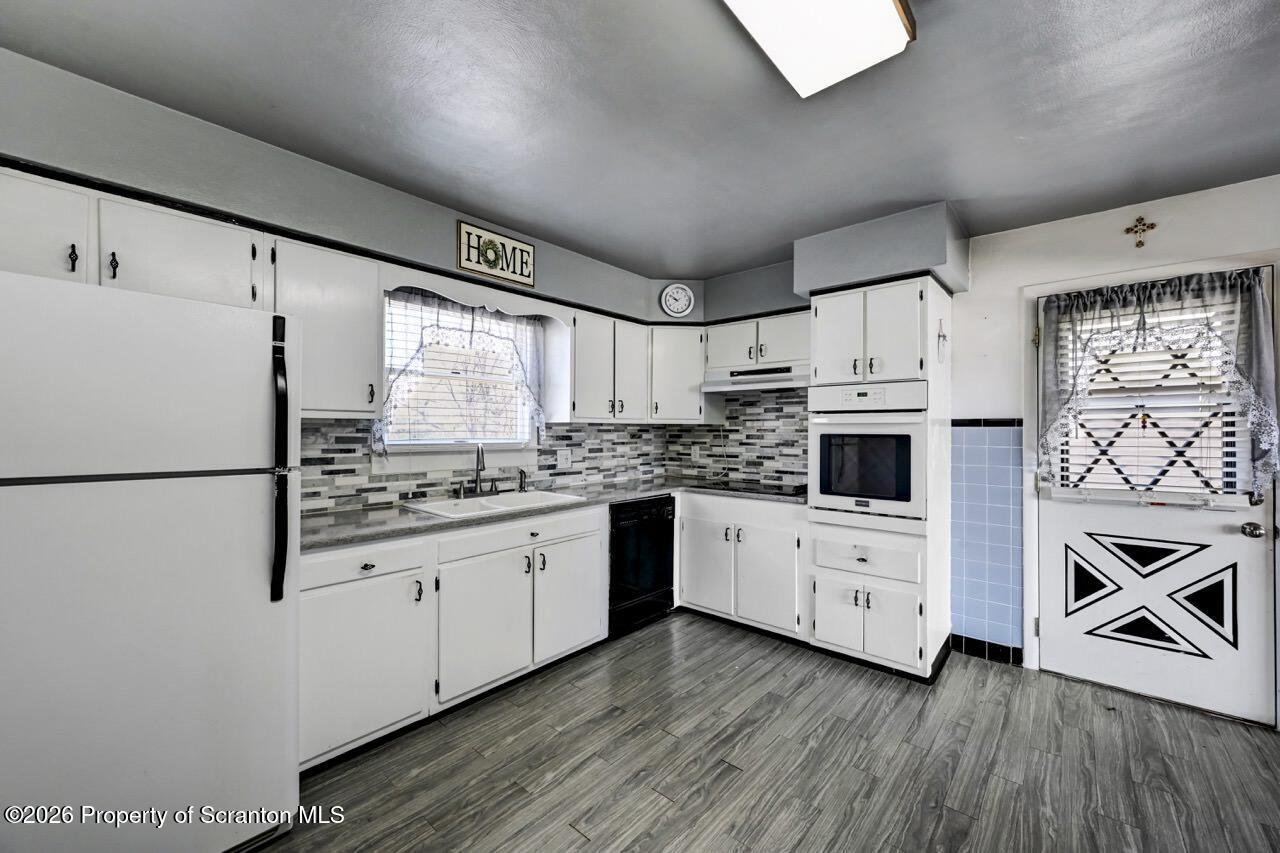 703 Ohara Street Scranton, PA 18505 - Photo 12 of 36 a kitchen with granite countertop white cabinets and white appliances