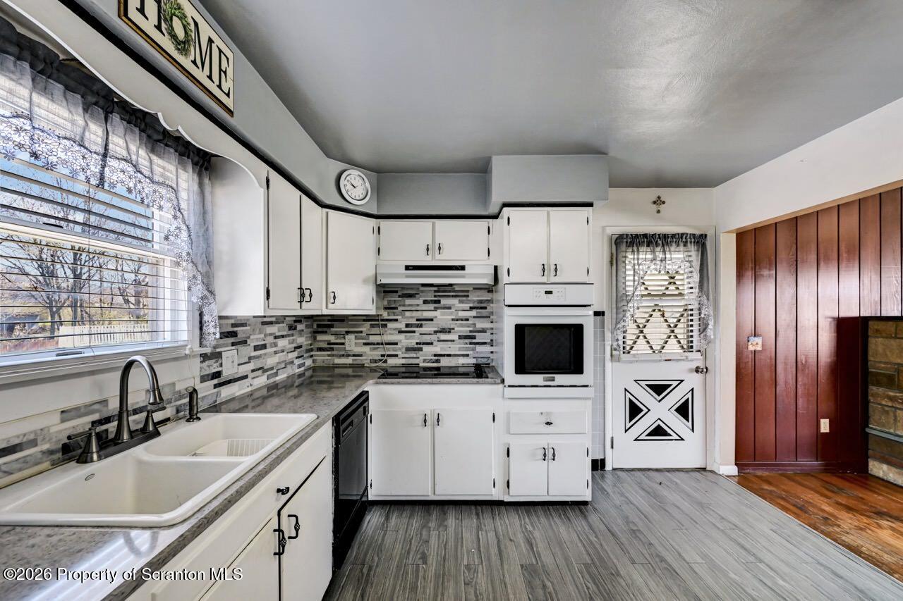 703 Ohara Street Scranton, PA 18505 - Photo 13 of 36 a kitchen with stainless steel appliances a stove top oven a sink a counter space and cabinets