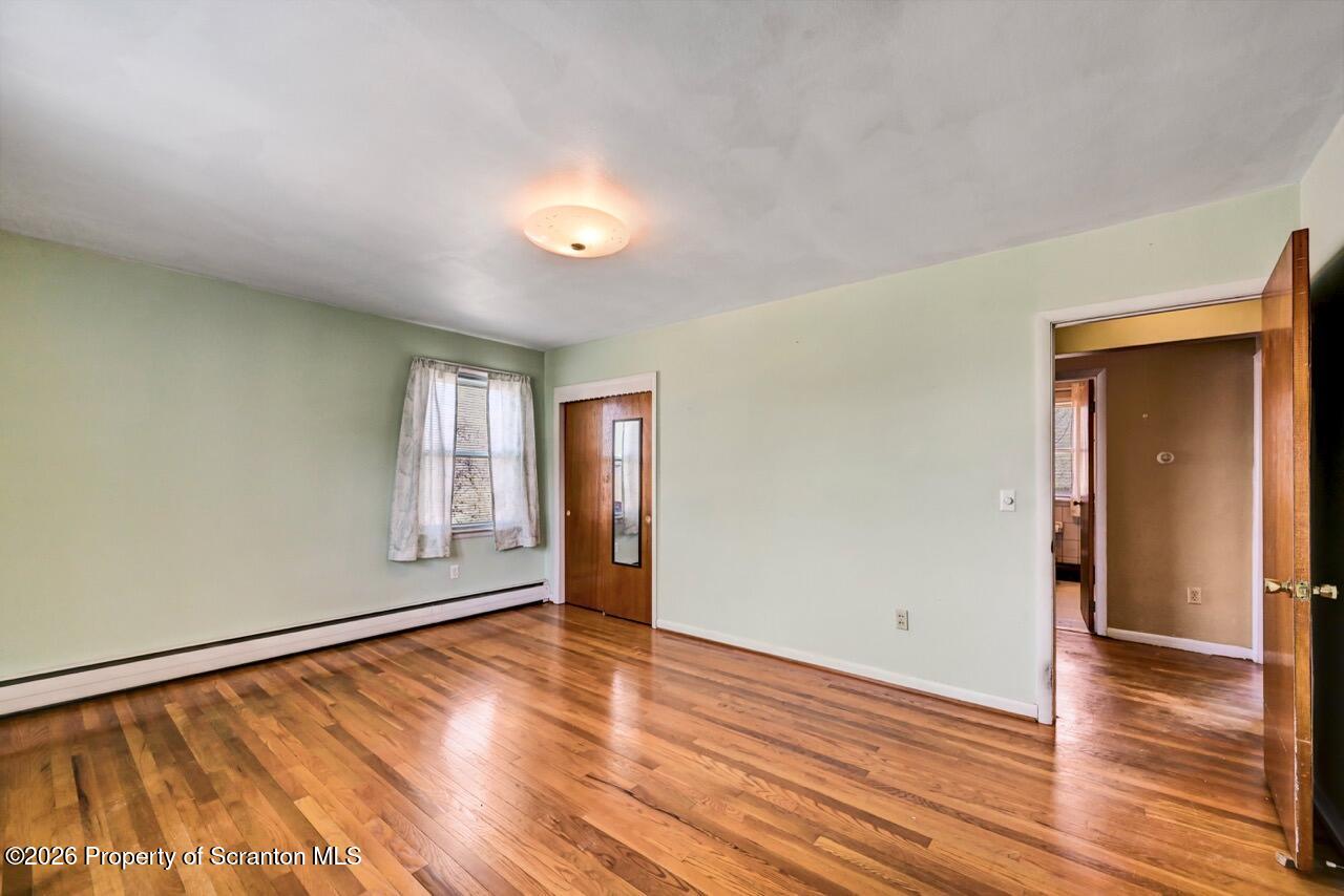 703 Ohara Street Scranton, PA 18505 - Photo 17 of 36 an empty room with wooden floor and windows