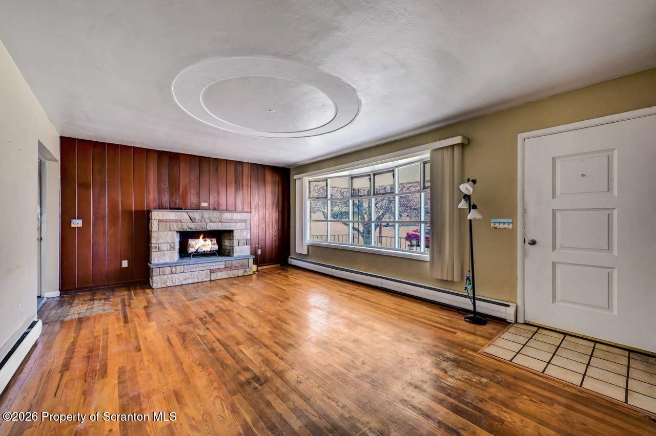 703 Ohara Street Scranton, PA 18505 - Photo 7 of 36 a view of an empty room with a fireplace and a window