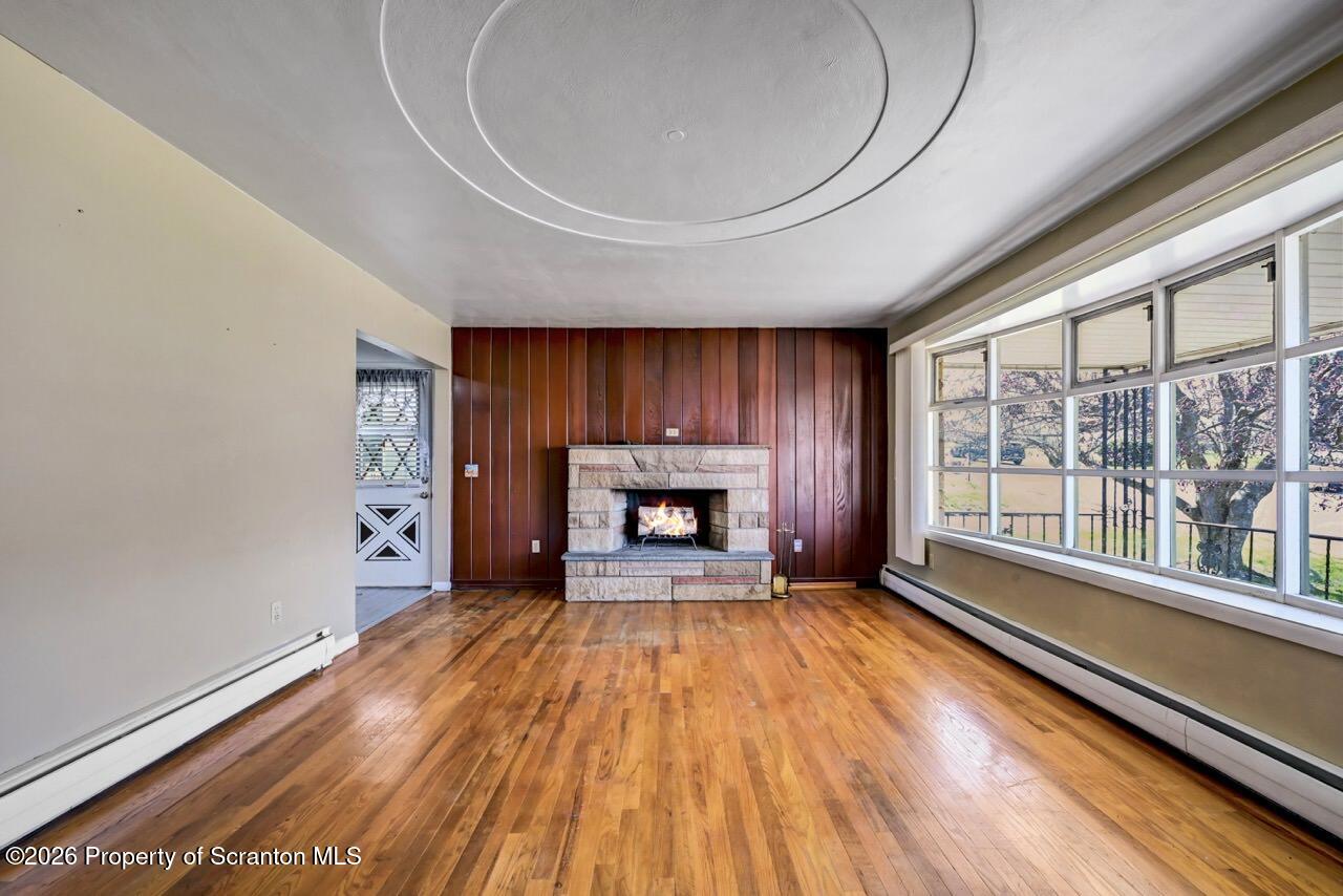 703 Ohara Street Scranton, PA 18505 - Photo 9 of 36 a view of an empty room with a window and wooden floor