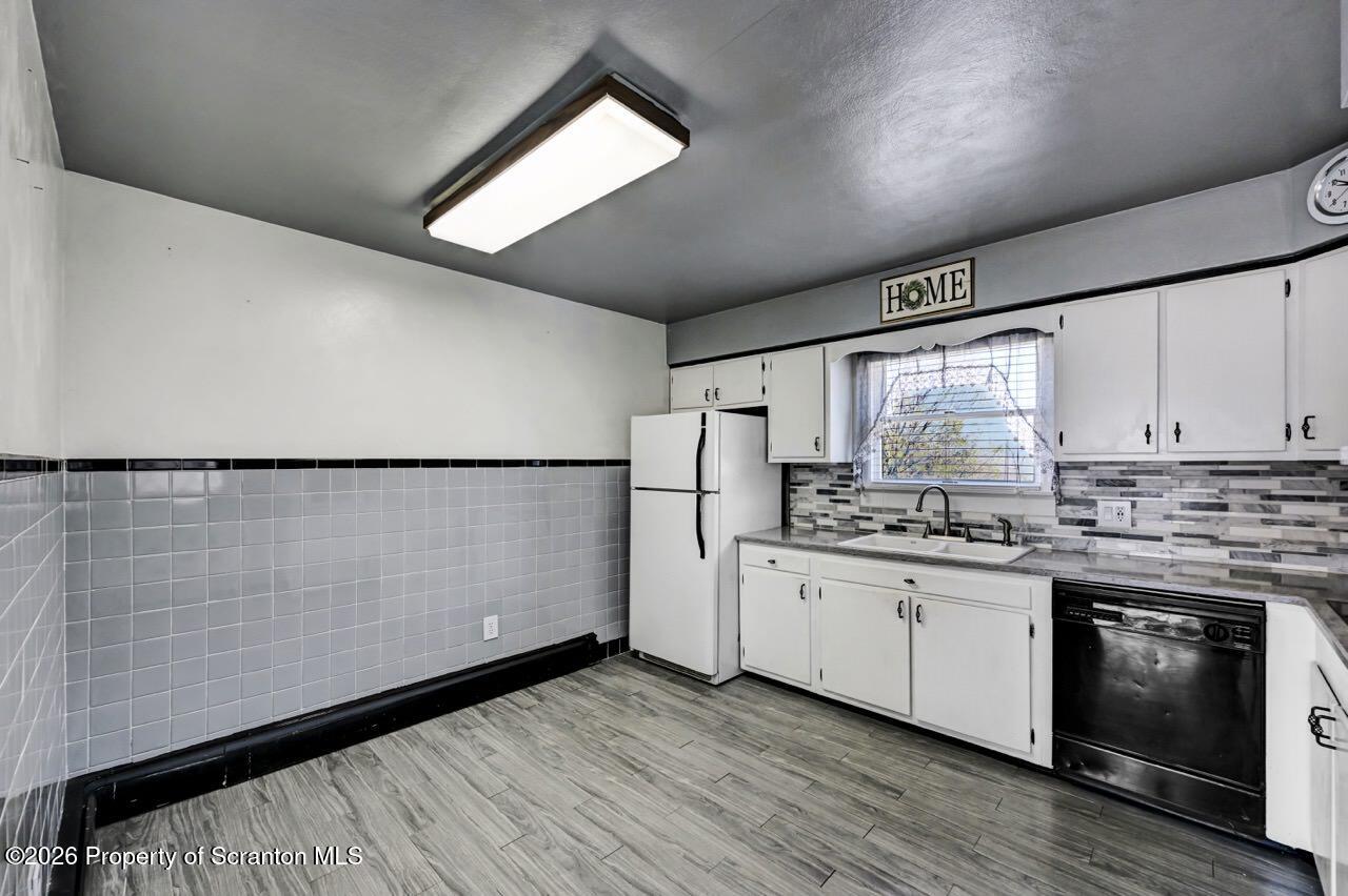 703 Ohara Street Scranton, PA 18505 - Photo 10 of 36 a kitchen with stainless steel appliances granite countertop a stove a sink and white cabinets