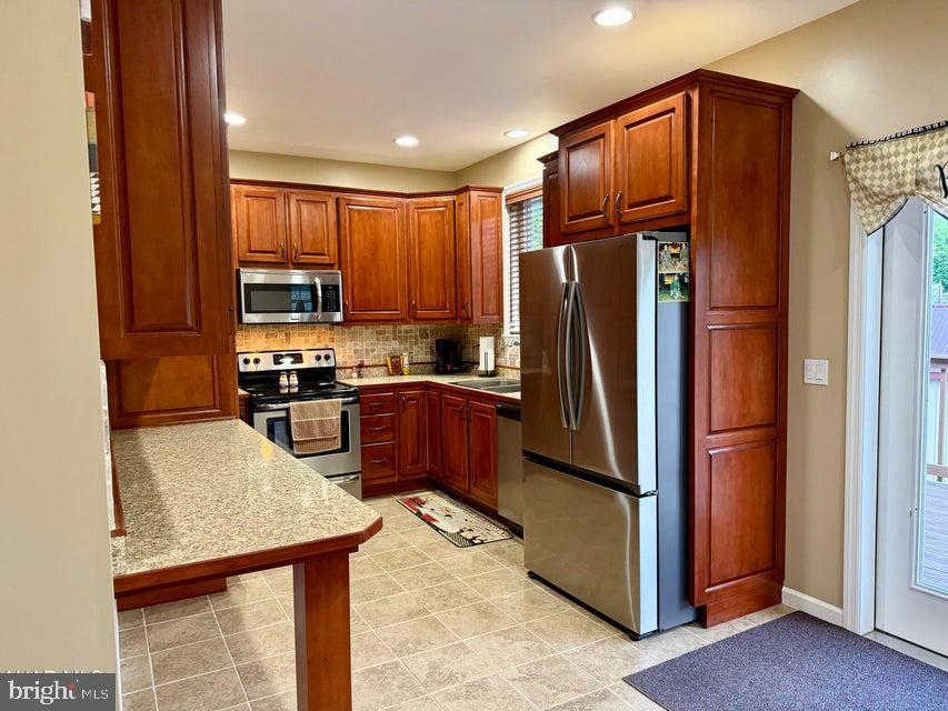 911 Lower Main Street Saxton, PA 16678 - Photo 25 of 63 a kitchen with stainless steel appliances granite countertop a refrigerator stove and cabinets