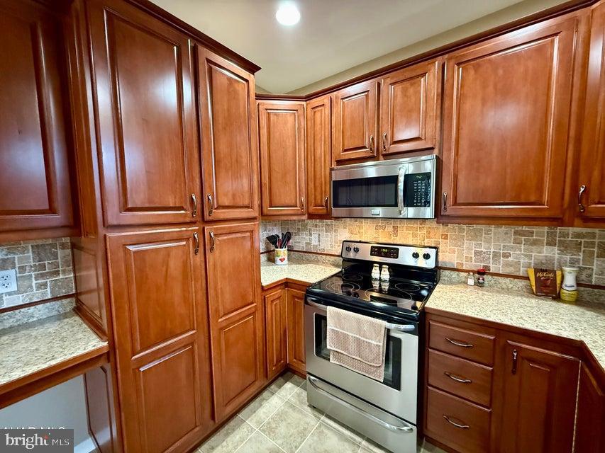 911 Lower Main Street Saxton, PA 16678 - Photo 27 of 63 a kitchen with granite countertop wooden cabinets stainless steel appliances and a window